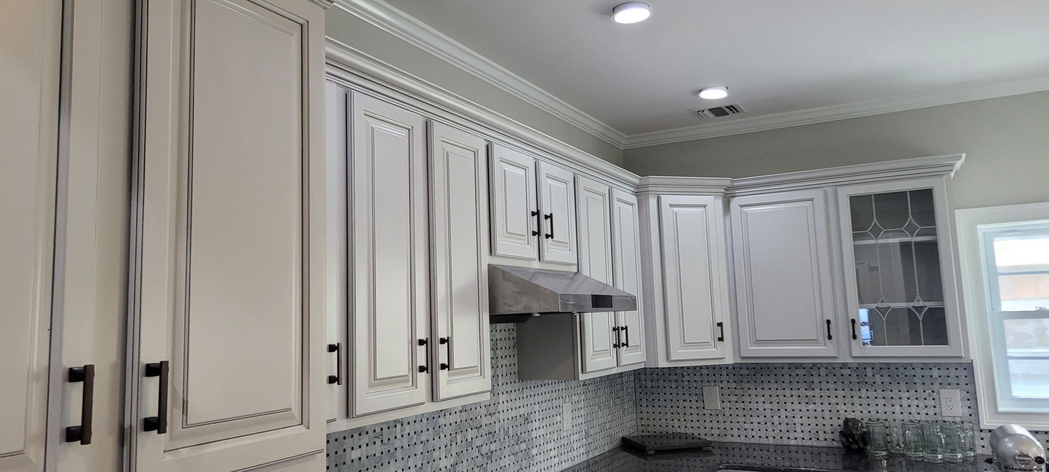 Kitchen upper cabinets refinished with off-white paint and dark antiquing glaze.