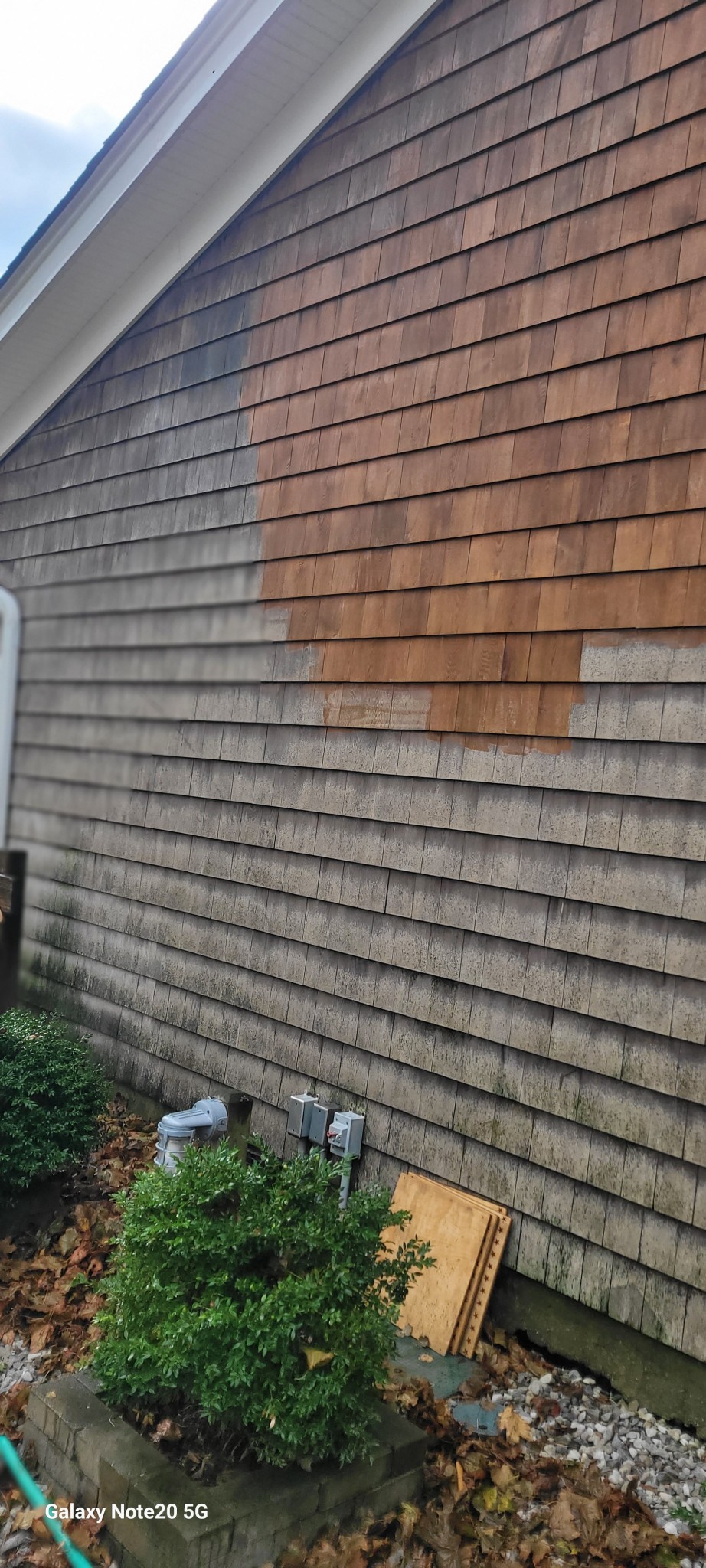 Exterior cedar shake siding undergoing cleaning and restoration process.